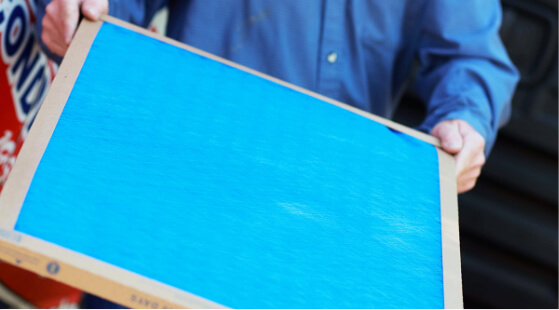 A technician holding an air filter.