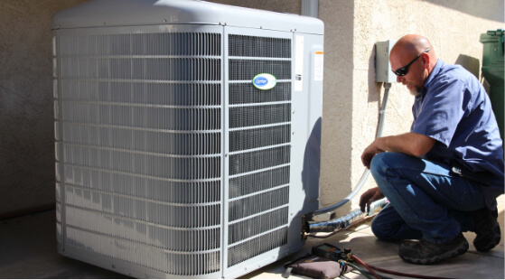 A technician looking at a large heating unit.