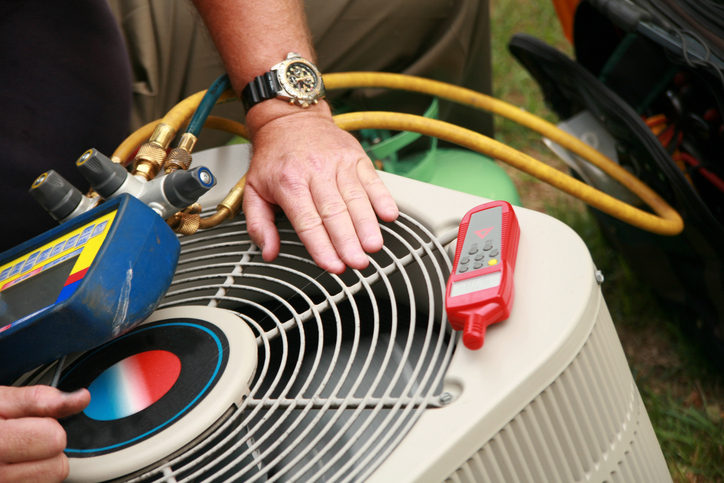 HVAC technician performing maintenance on an ac unit